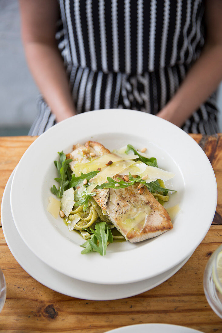 Grilled fish with pasta, rocket, Parmesan and pine nuts