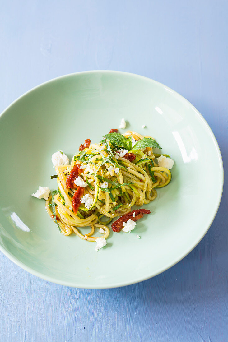 Courgette noodles with dried tomatoes, feta cheese and mint