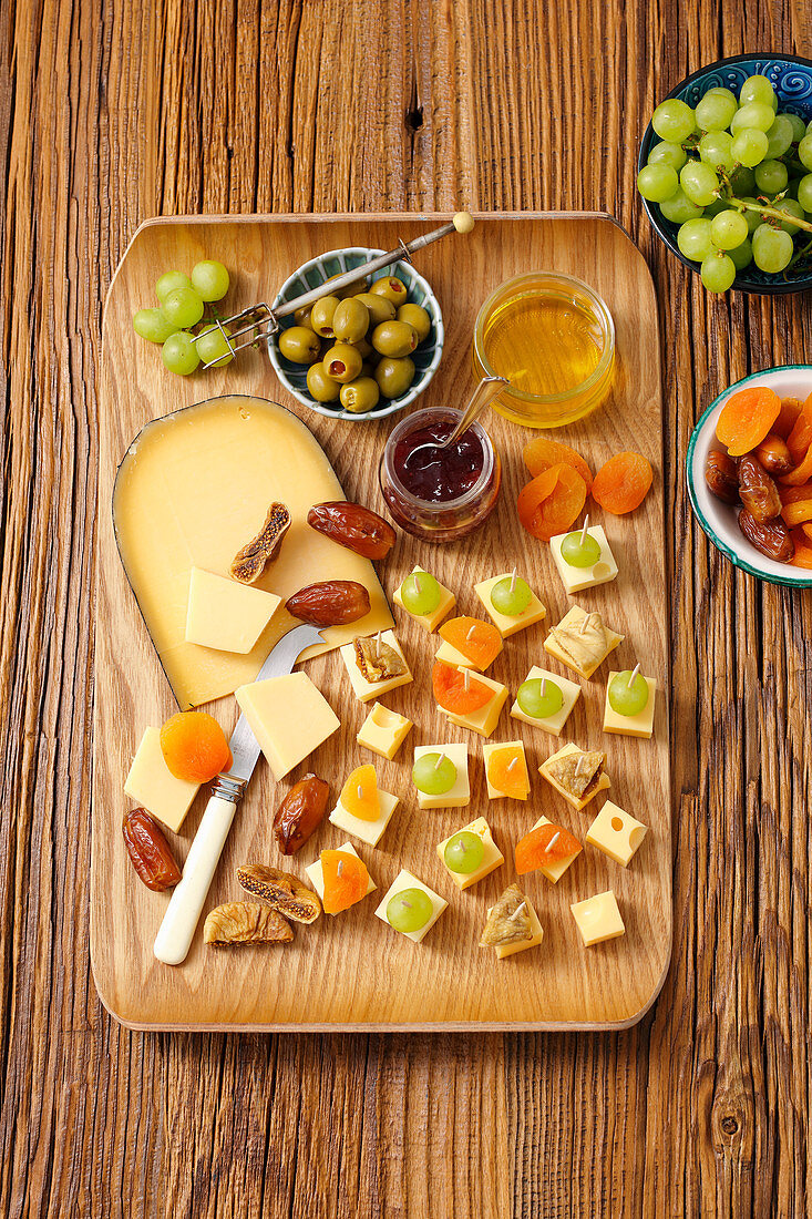 Cheese appetizers with grapes, olives, dried apricots