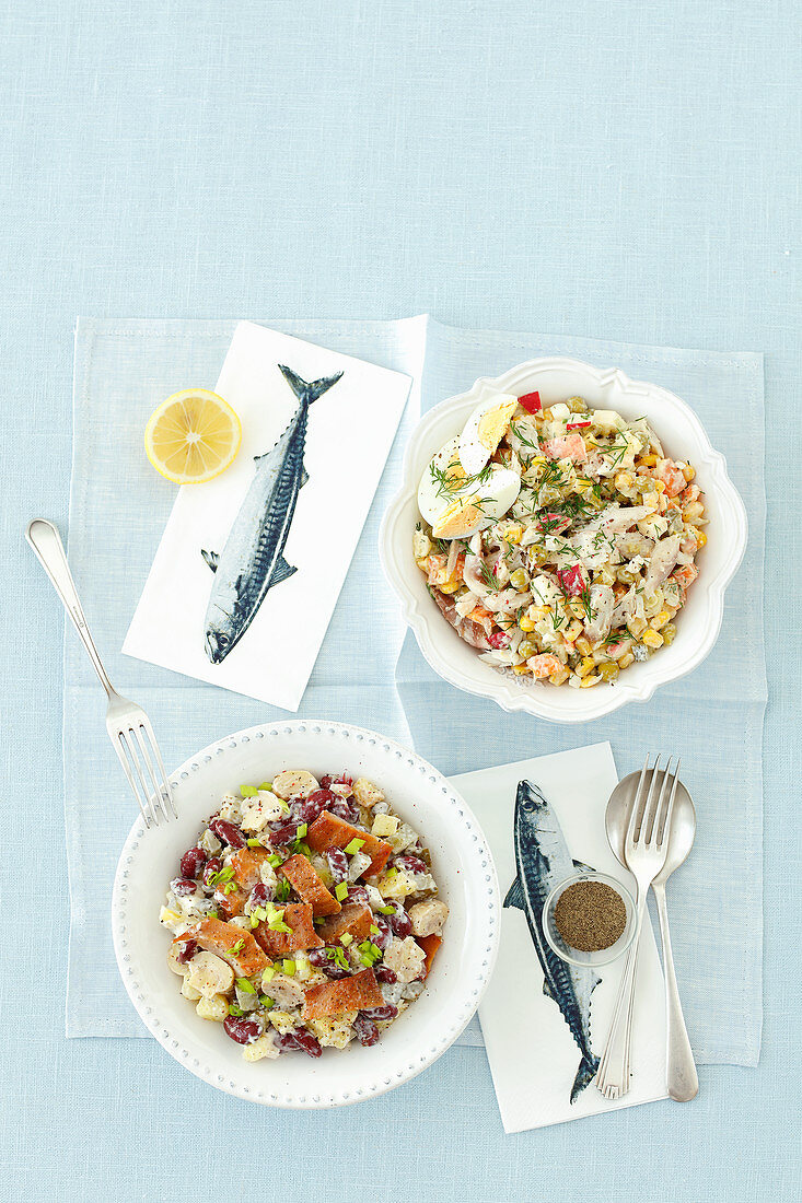 Zwei verschiedene Gemüsesalate mit Räucherfisch