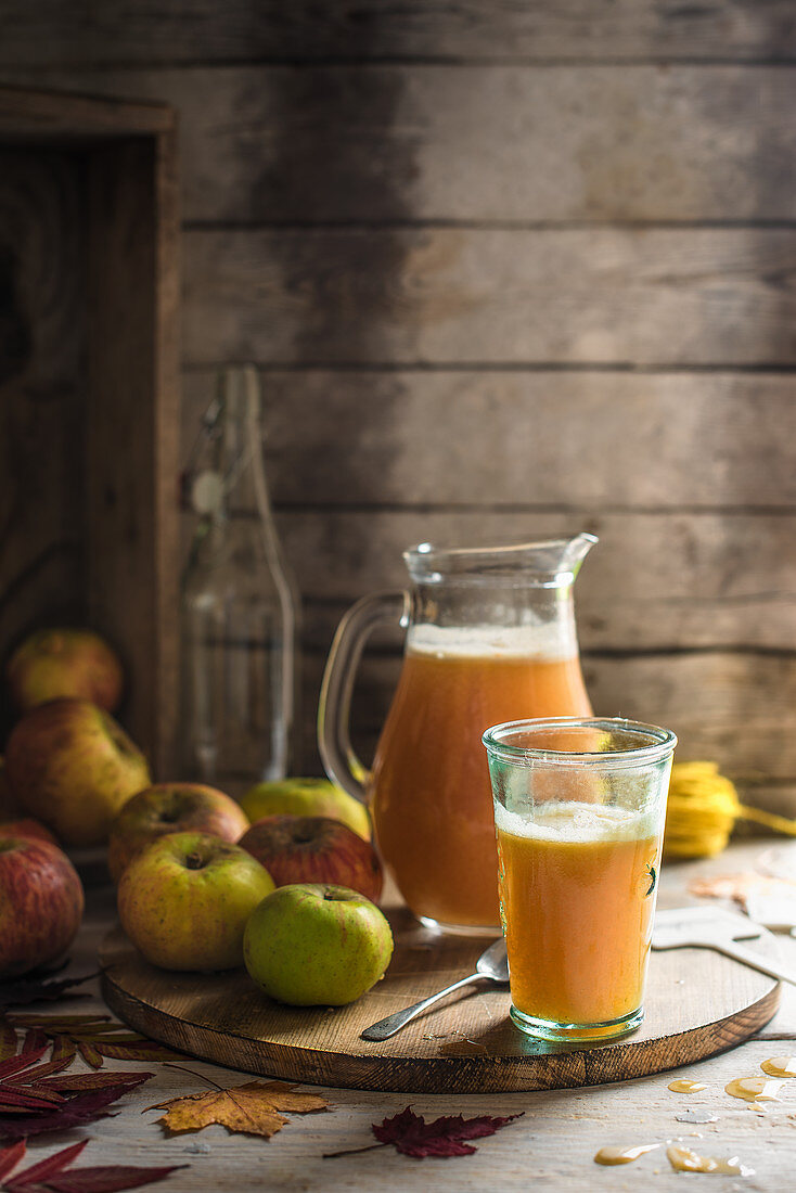 Freshly pressed apple juice in a jug and glass with apples