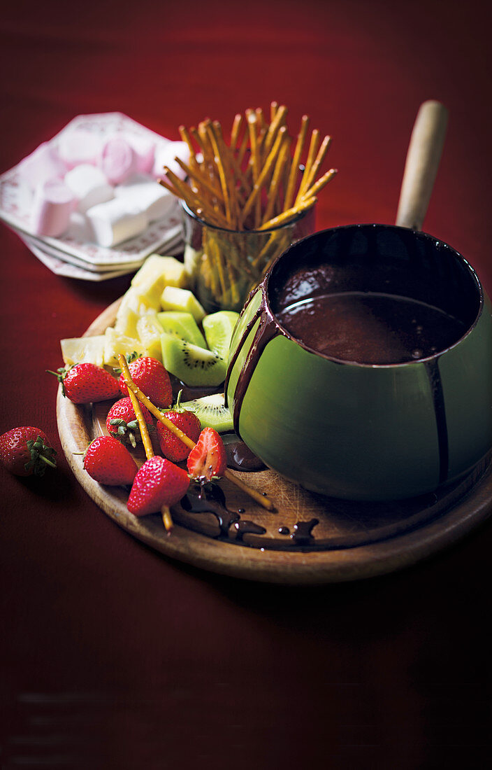 Schokoladenfondue mit Früchten und Salzstangen