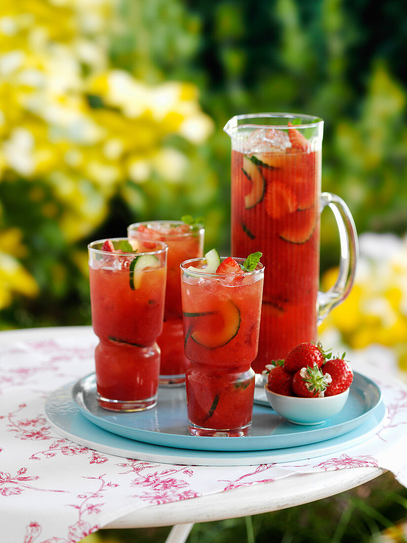 Eistee im Glas mit Gurken und Erdbeeren