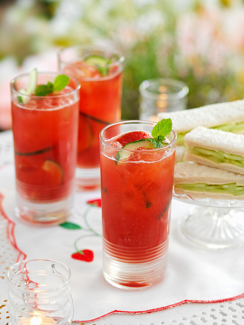 Eistee im Glas mit Gurken und Erdbeeren