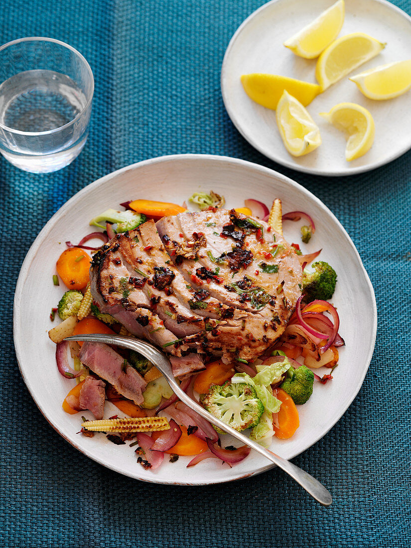 A tuna steak with broccoli and carrots