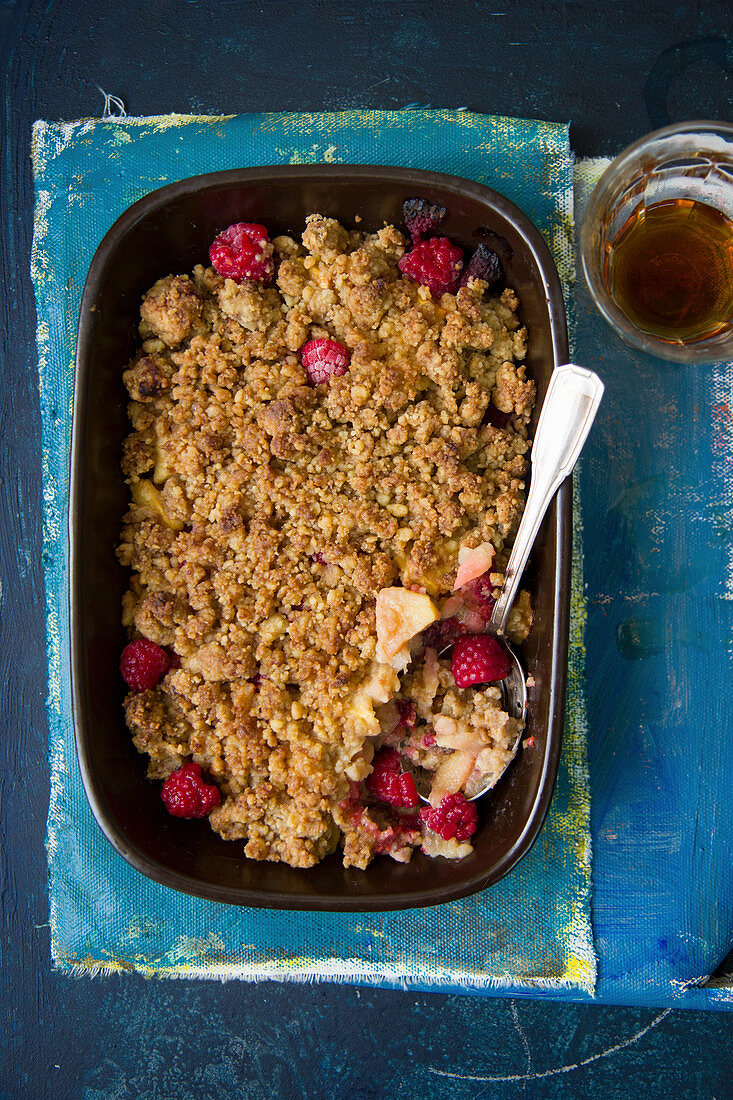 Apple and raspberry crumble in a baking dish (seen from above)