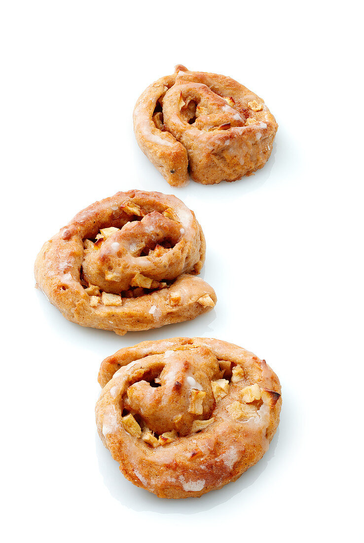 Three apple and cinnamon buns on a white surface