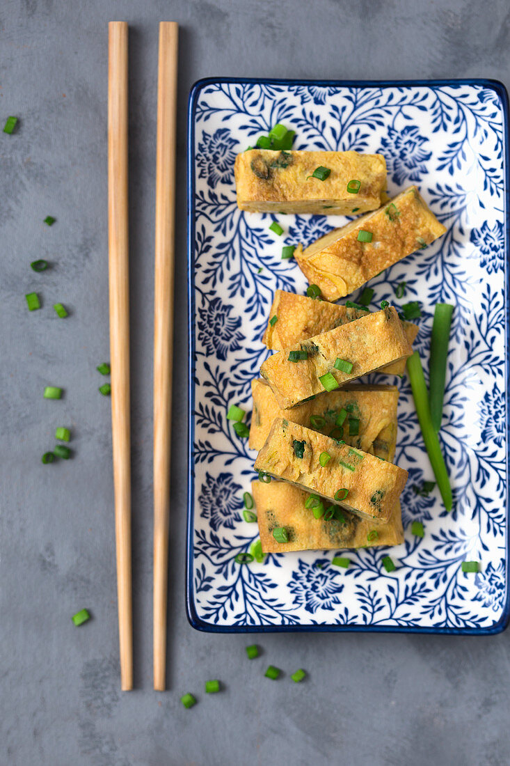 Gerolltes Omelett (Tamagoyaki) mit frischem Schnittlauch (Japan)