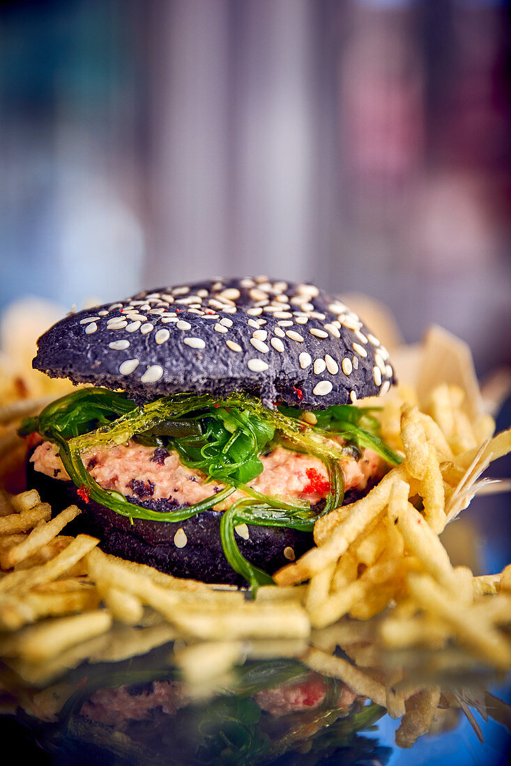 A black burger with crab meat and algae