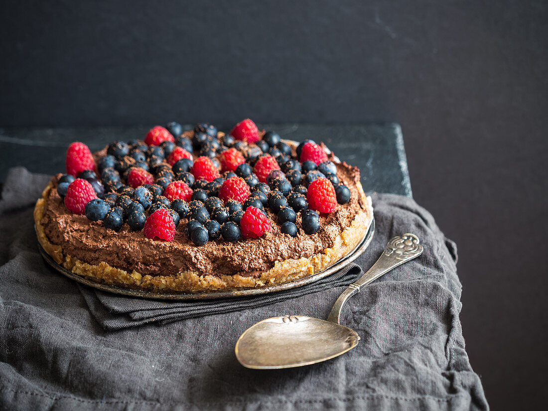 Raw vegan gluten-free chocolate tart with berries