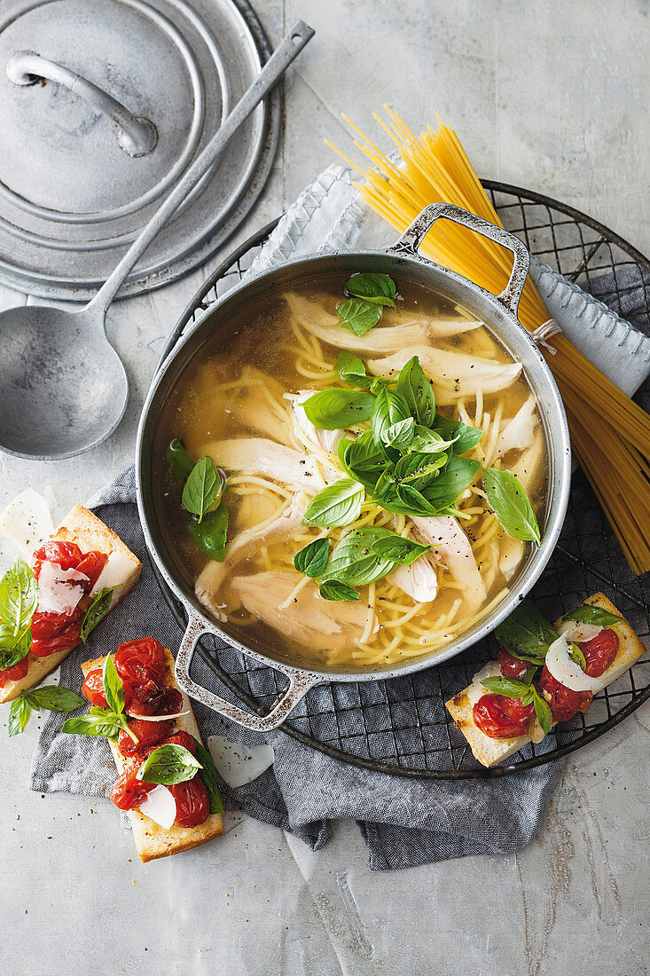 Nudelsuppe mit Hähnchen, dazu Ciabatta mit gebratenen Tomaten (Italien)