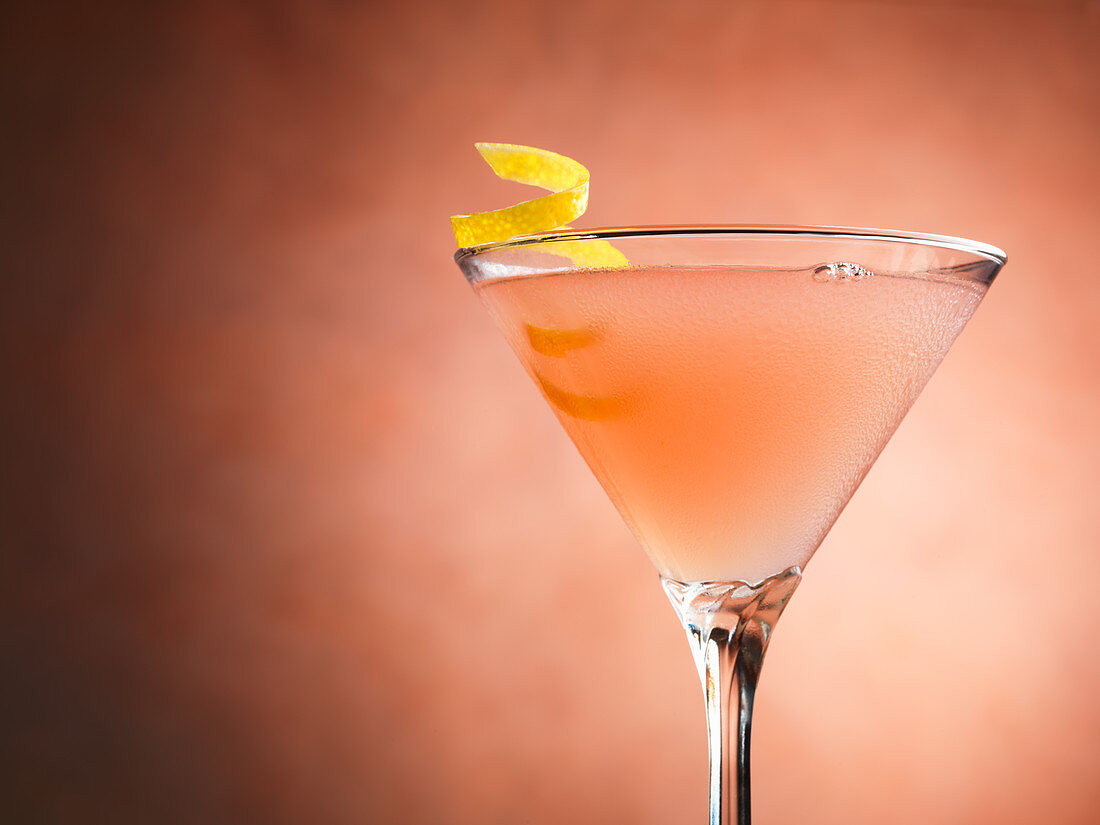 A Cosmopolitan cocktail in front of a coloured background