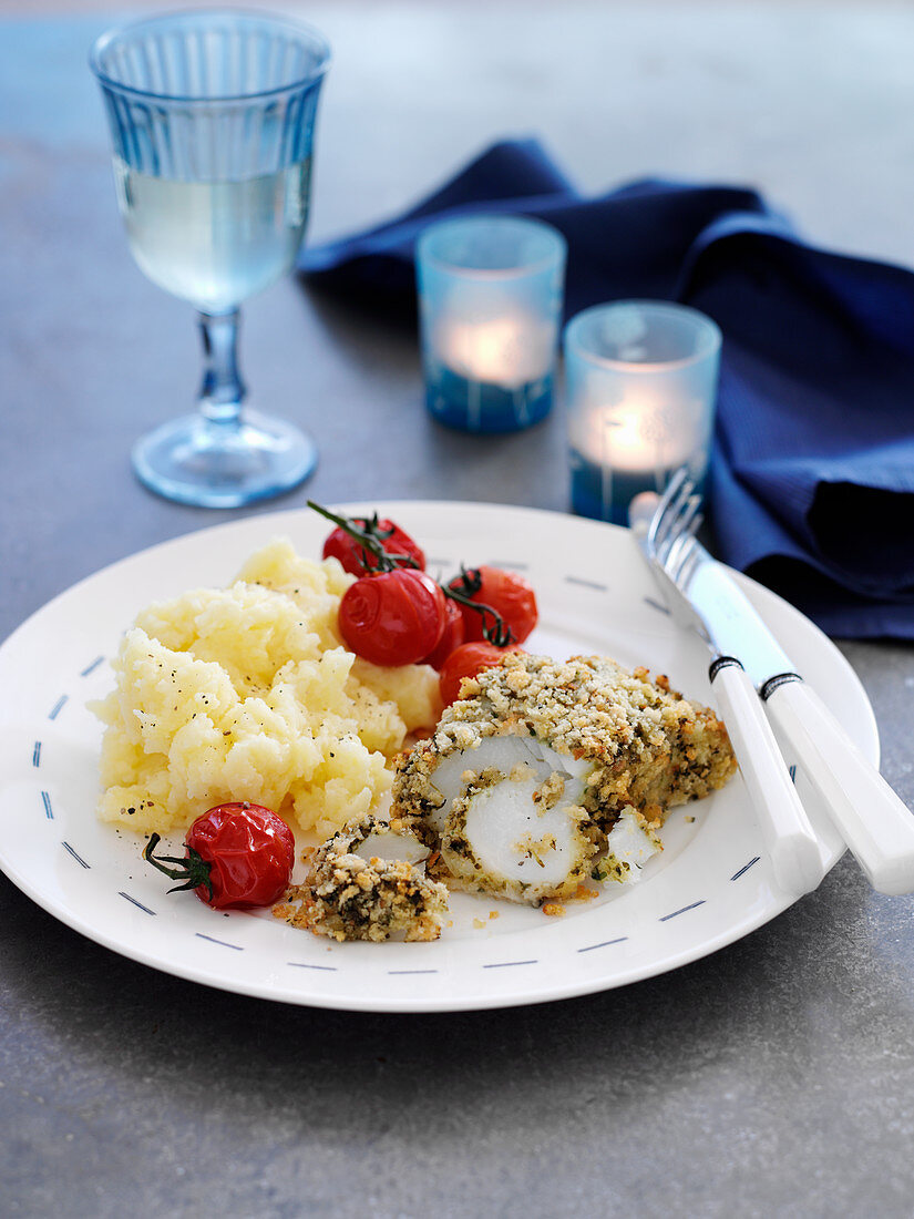 Cod coated in pesto with mashed potatoes and tomatoes