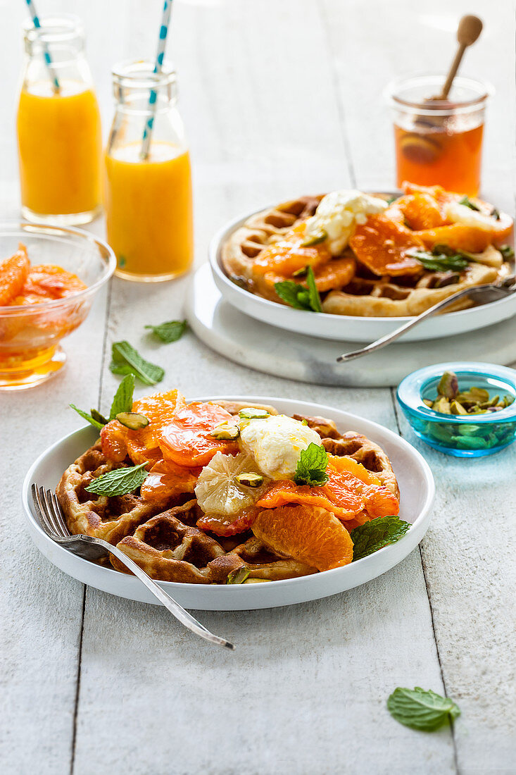 Waffles with citrus fruits, honey, labneh and pistachio nuts