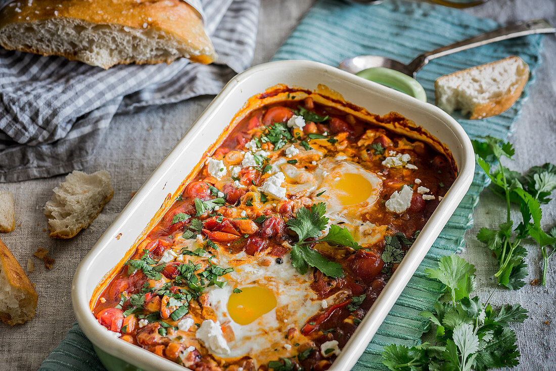 Tomato stew with poached eggs, chickpeas and parsley