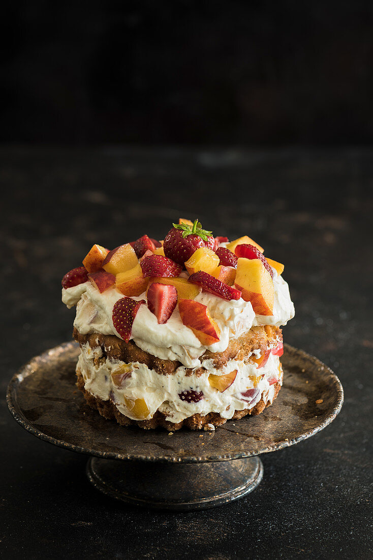 A small naked cake with peaches, strawberries and mascarpone cream