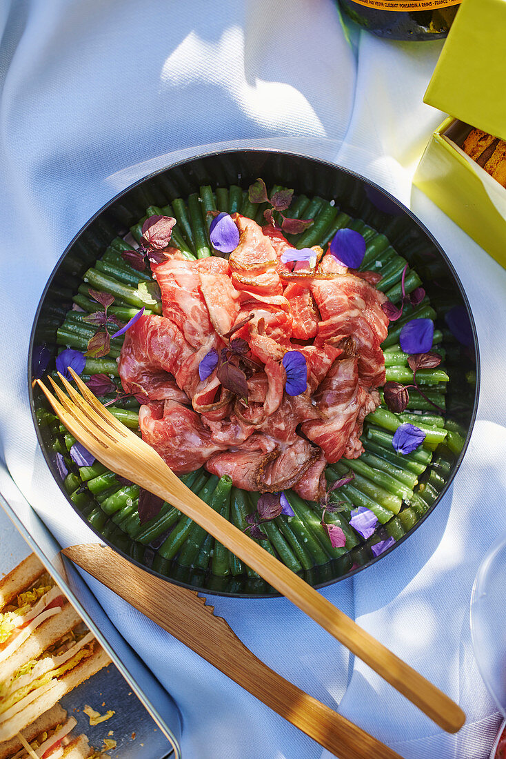 A picnic salad with green beans and beef