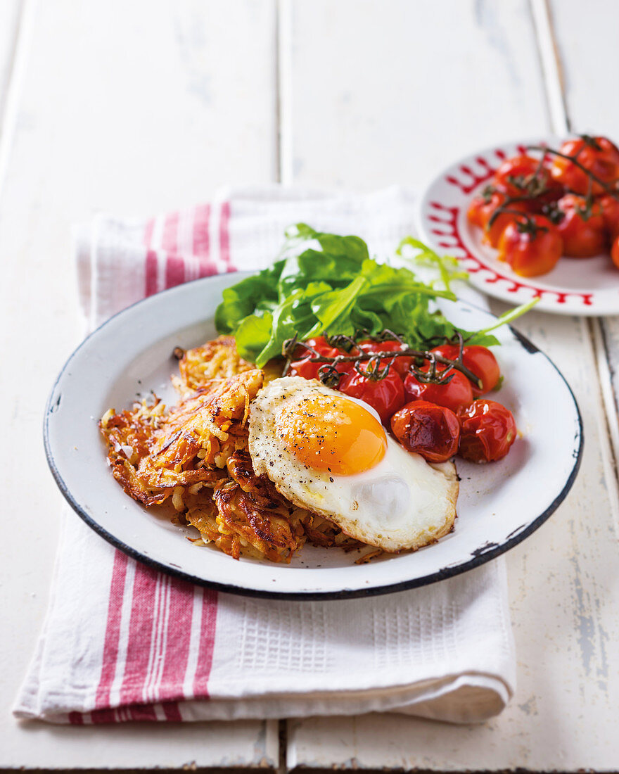 Latkas with a fried egg and roasted tomatoes