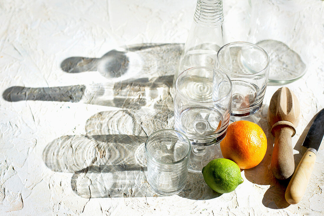 Ingredients and utensils for making blood orange spritzers with lime