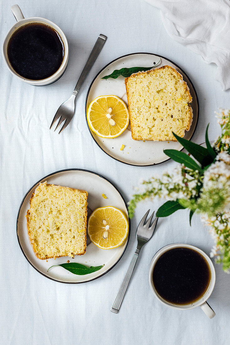 Zitronen-Zucchini-Kuchen in Scheiben auf Tellern (Aufsicht)