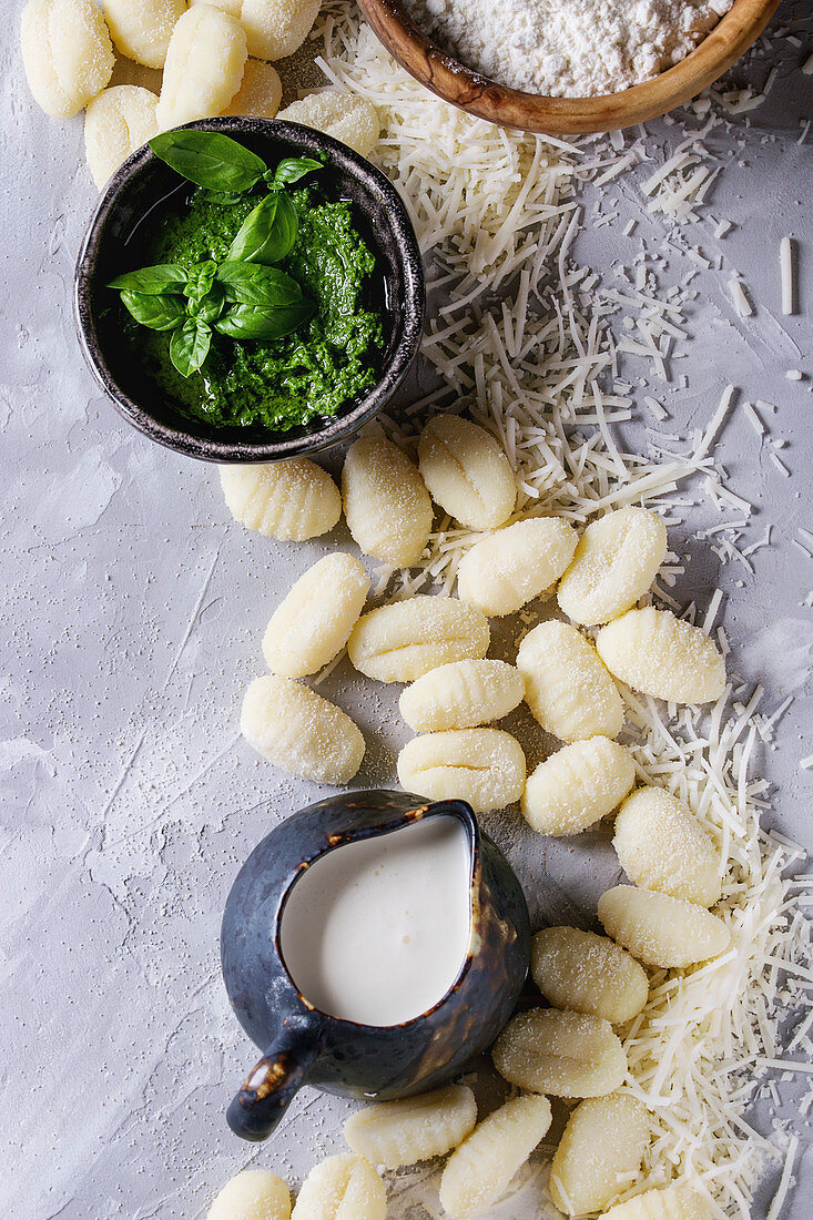 Raw uncooked potato gnocchi in black wooden plates with ingredients
