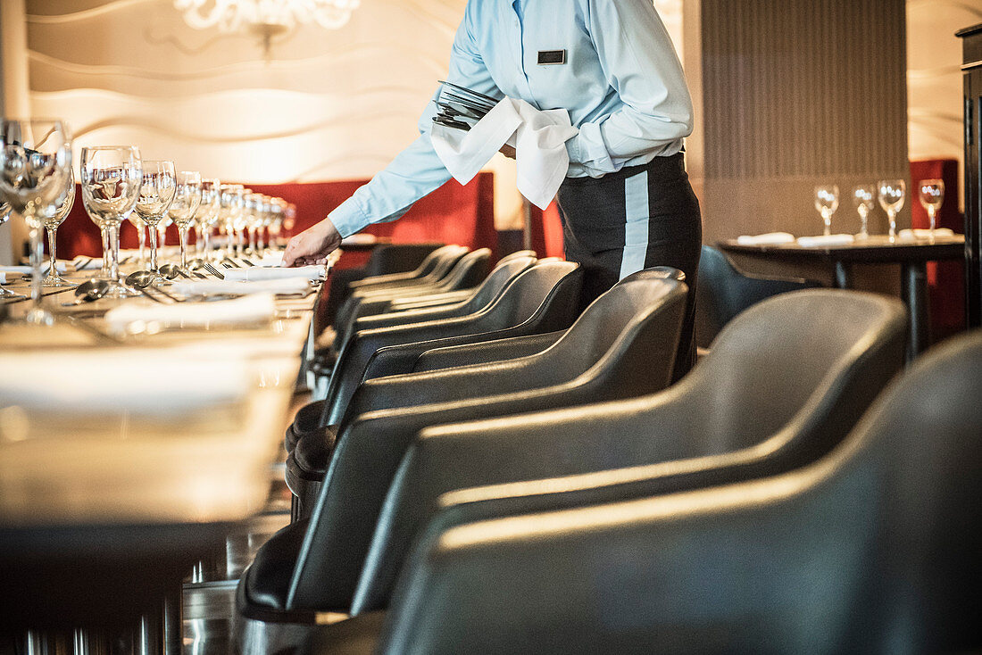 A waitress laying tables in a restaurant