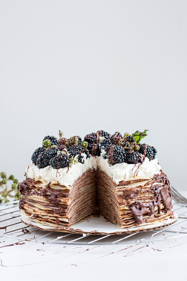 A pancake cake with chocolate and blackberries