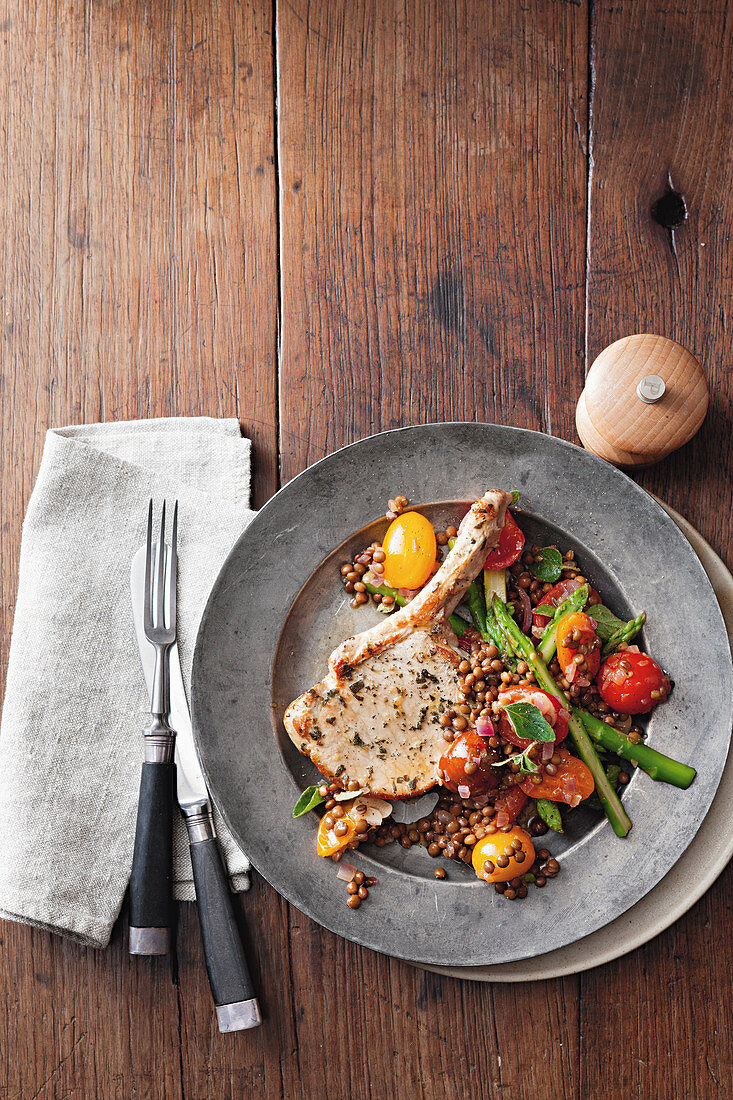 Schweinekotelett mit geschmorten Linsen, Tomaten und Spargel