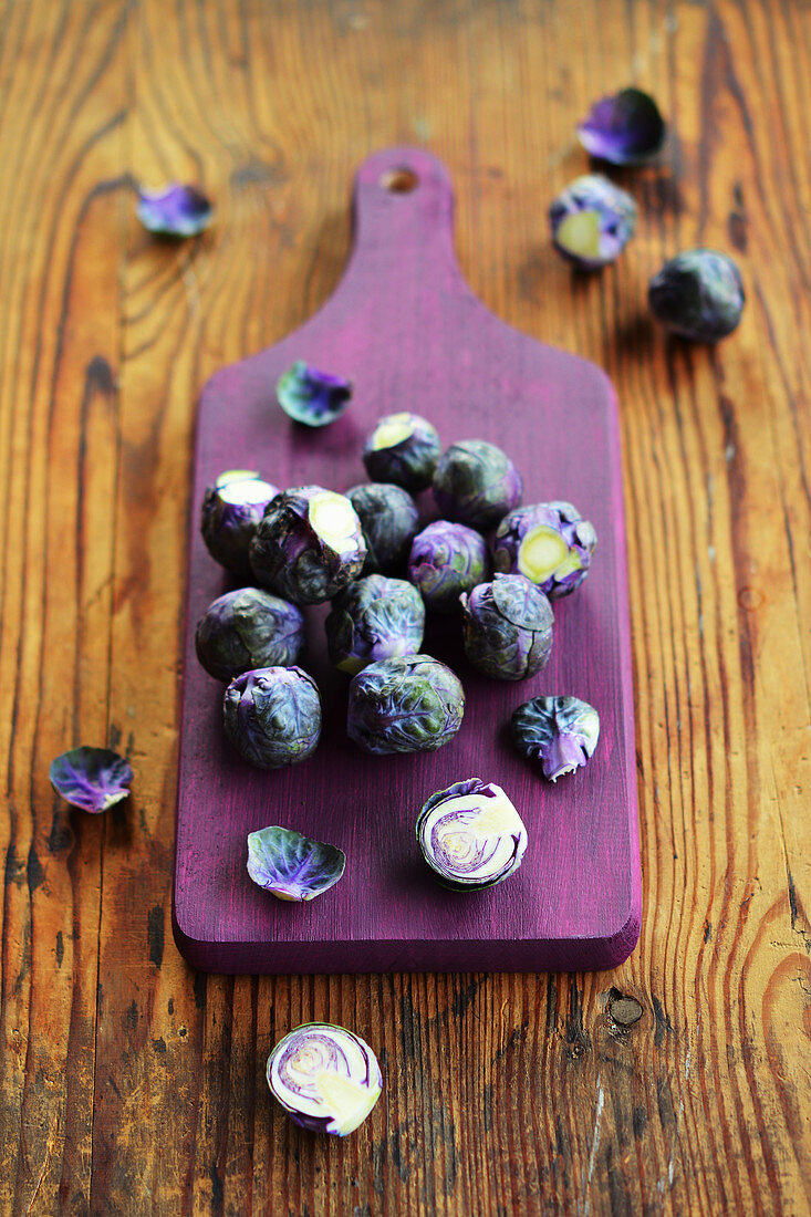 Fresh Brussels sprouts on a purple chopping board