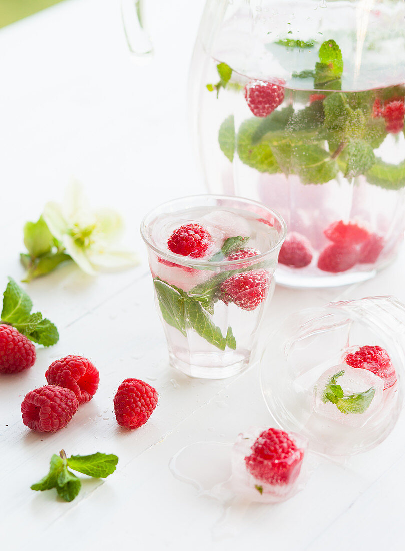 Water flavoured with raspberries, mint and ice cube