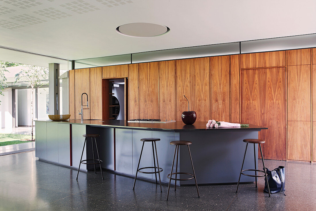 Island counter and fitted wooden cupboards in open-plan kitchen