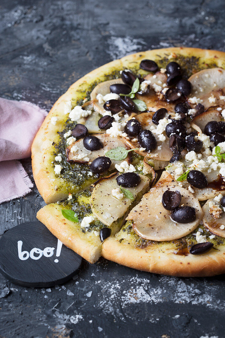 Schwarz-weiße Pizza mit Navetten, Oliven und Feta für Halloween