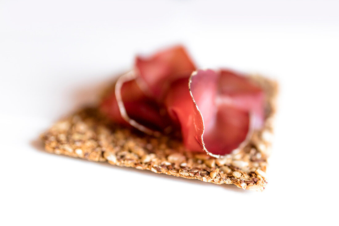 A slice of bresaola on a cracker (Veltlin, Lombardy, Italy)