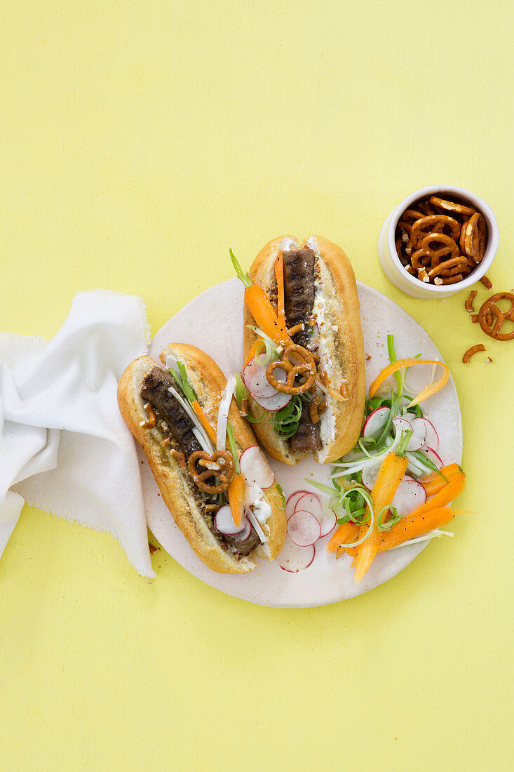 Hotdog mit Boerewors (Grillwurst, Südafrika), Karottensalat und Salzbrezeln
