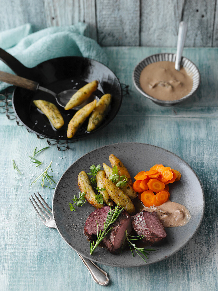 Saddle of venison with potato orzo herb pasta, caramelised carrots and a porccini mushroom sauce