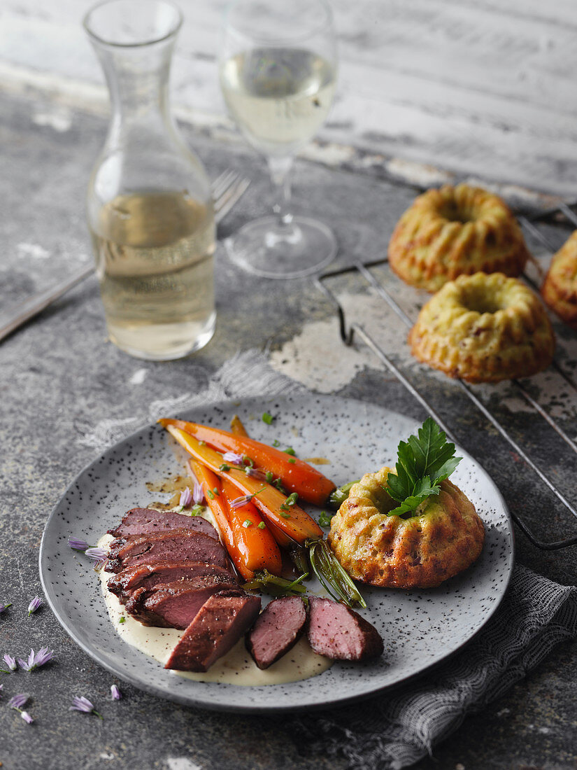 Saddle of young goat with Döppekooche (potato cakes from the Eifel region) and caramelised carrots (Germany)