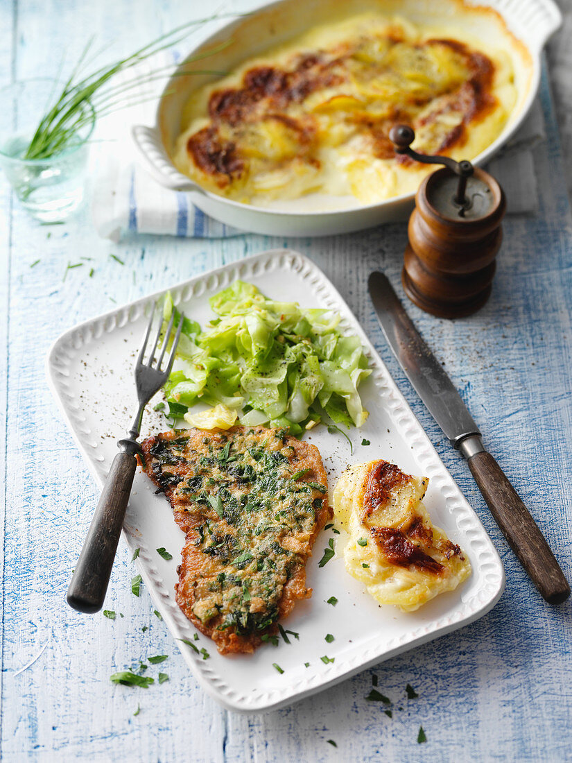 Veal escalope with a herb coating with pointed cabbage and potato gratin