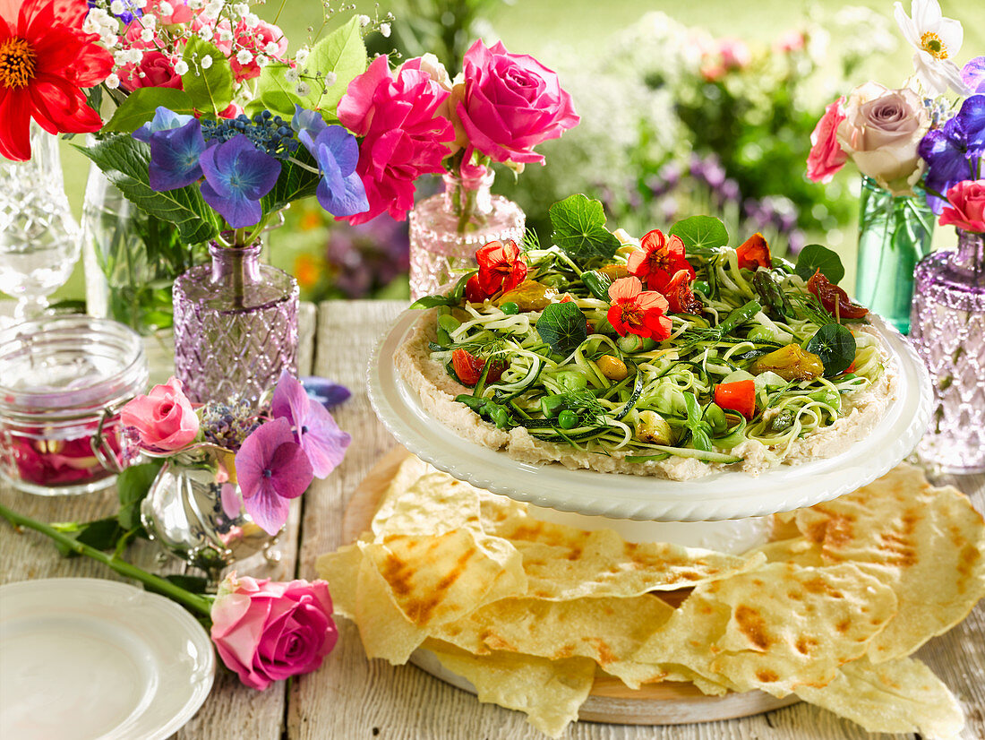 Summer salad with edible flowers, hummus and flatbread