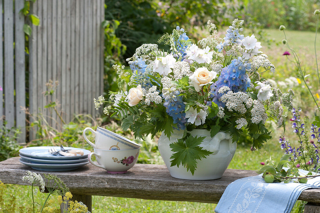 Blue and white bouquet in soup tureen on garden bench
