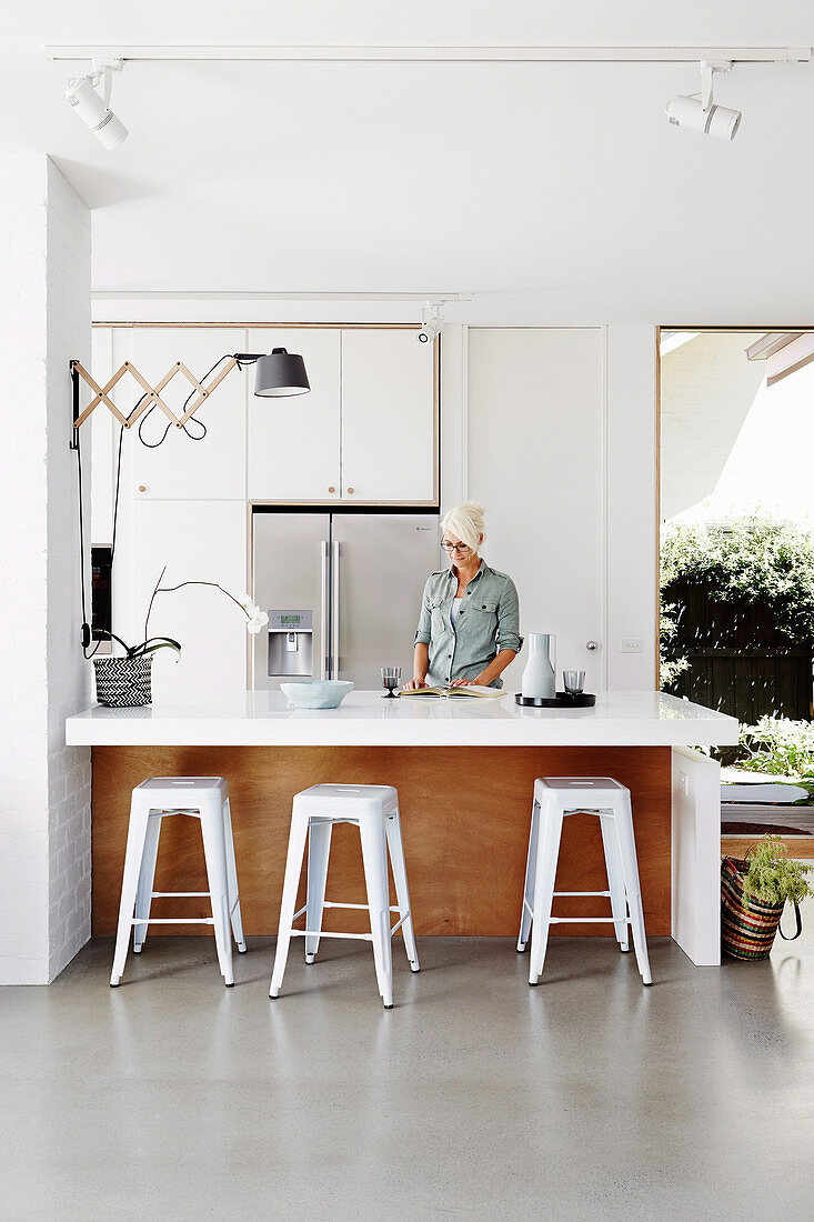 Kitchen counter with bar stool, woman behind the counter