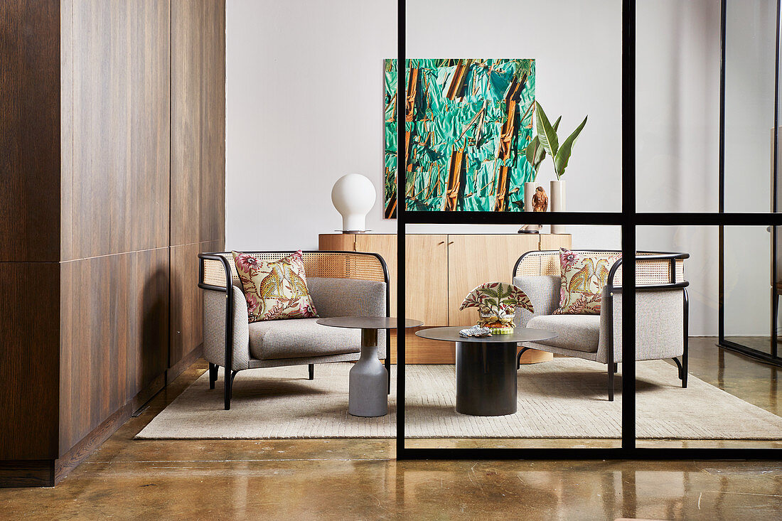 Designer lounge chairs and coffee table in front of sideboard with fitted cupboards to one side