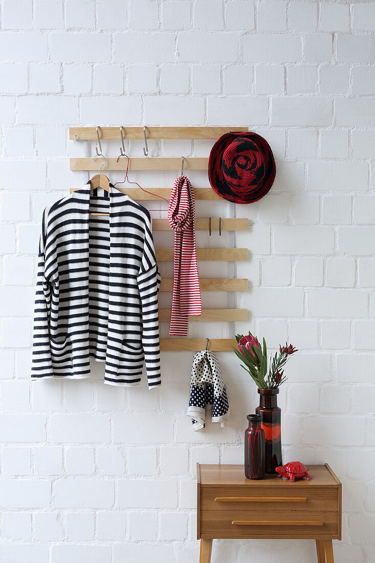 Coat rack made from old bed slats on brick wall