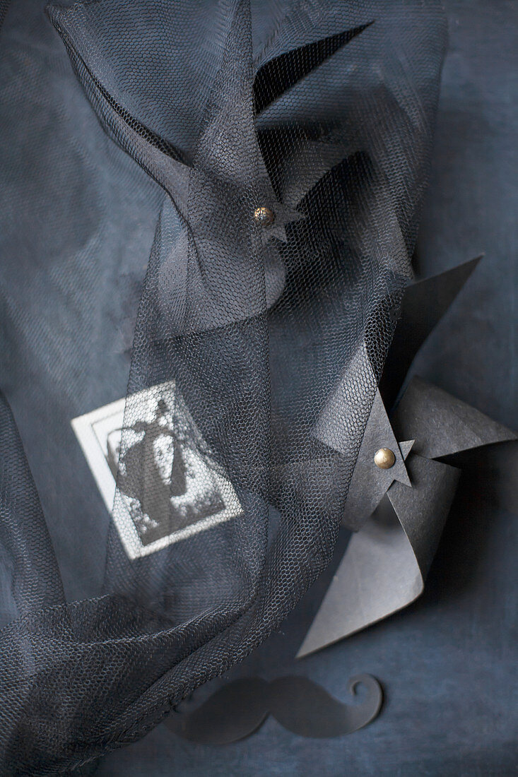 Two windmills handmade from black paper under tulle
