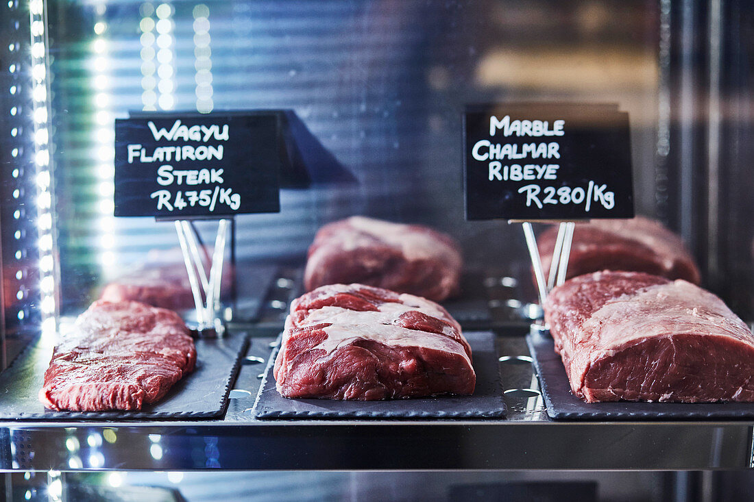 Rindfleischsorten (Flat Iron Steak vom Wagyu-Rind, Ribeye-Steak) mit Preisschildern