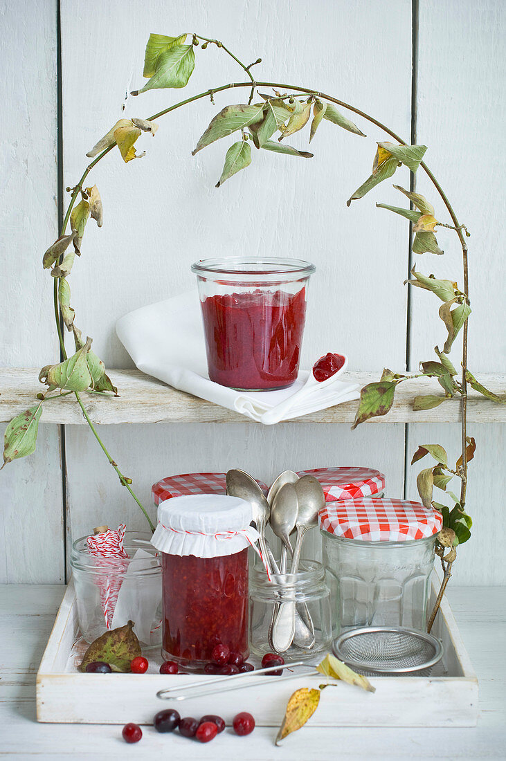 Cornelian jam in storage jars under a cornel cherry branch