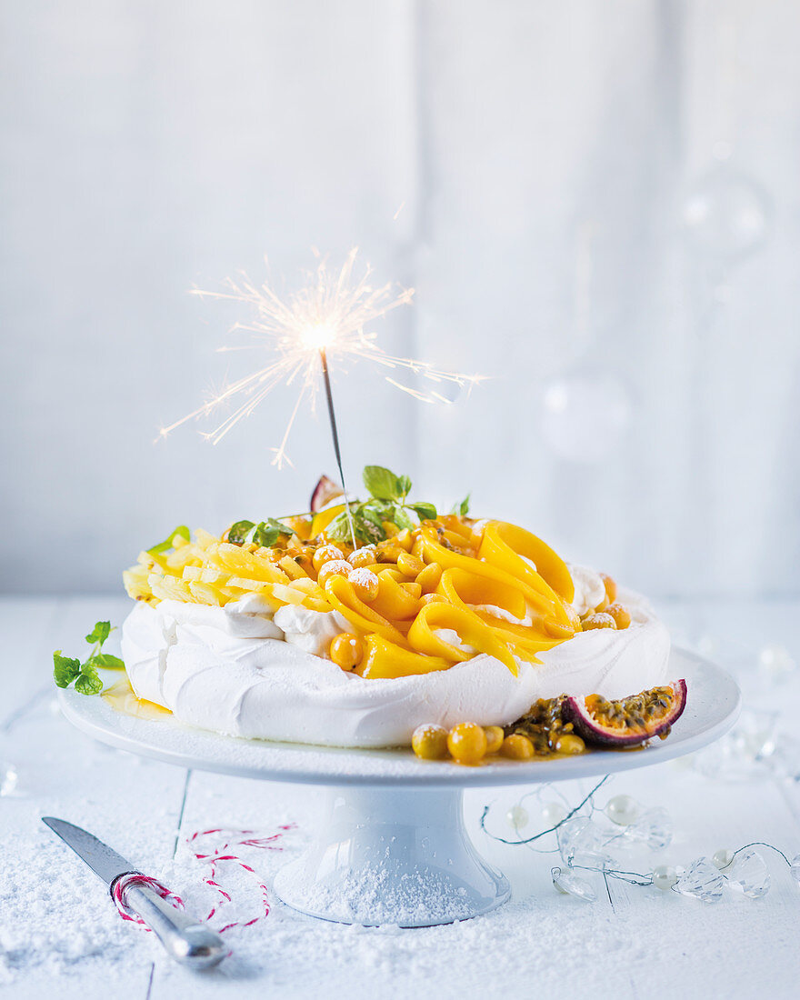 Pavlova with exotic fruits and a sparkler