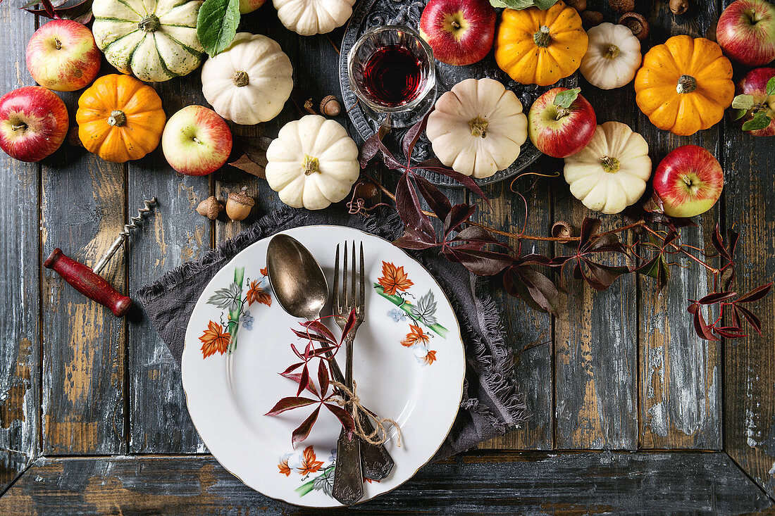 Herbstliche Tischdekoration mit Kürbissen, Äpfeln und Weinlaub