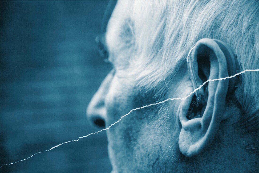 Elderly man using a hearing aid