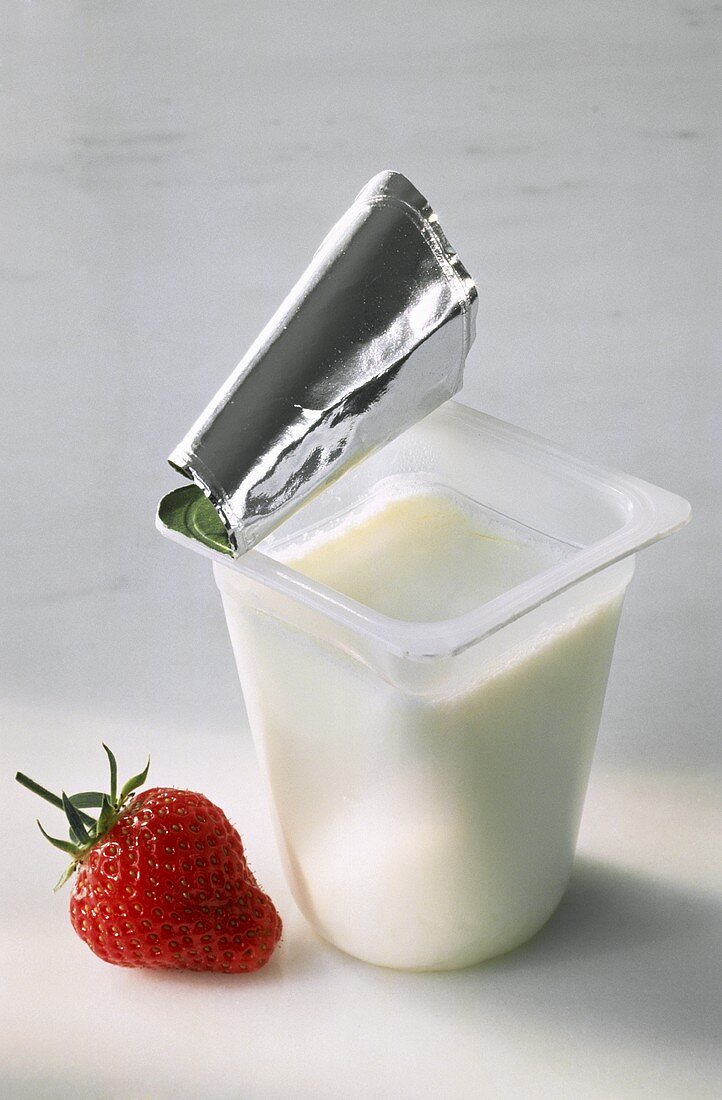 An Opened Container of Plain Yogurt; Strawberry