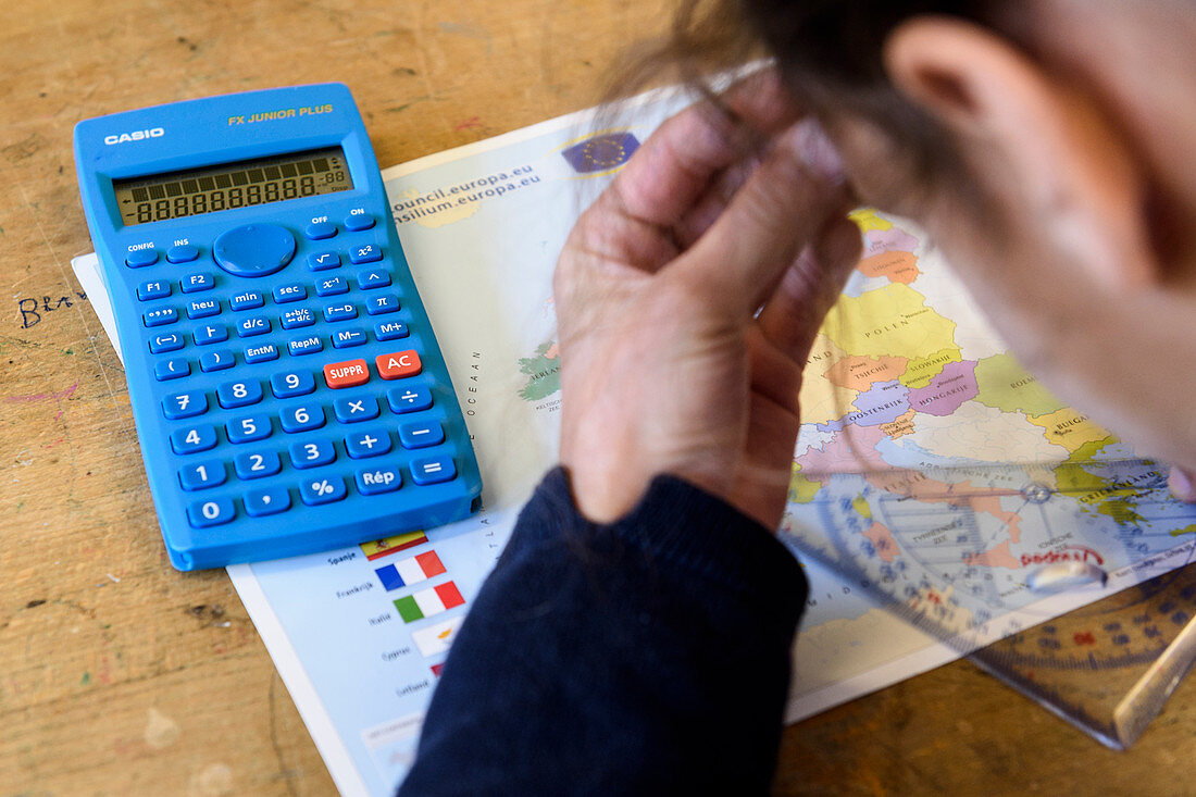 Student with a calculator, map and protractor